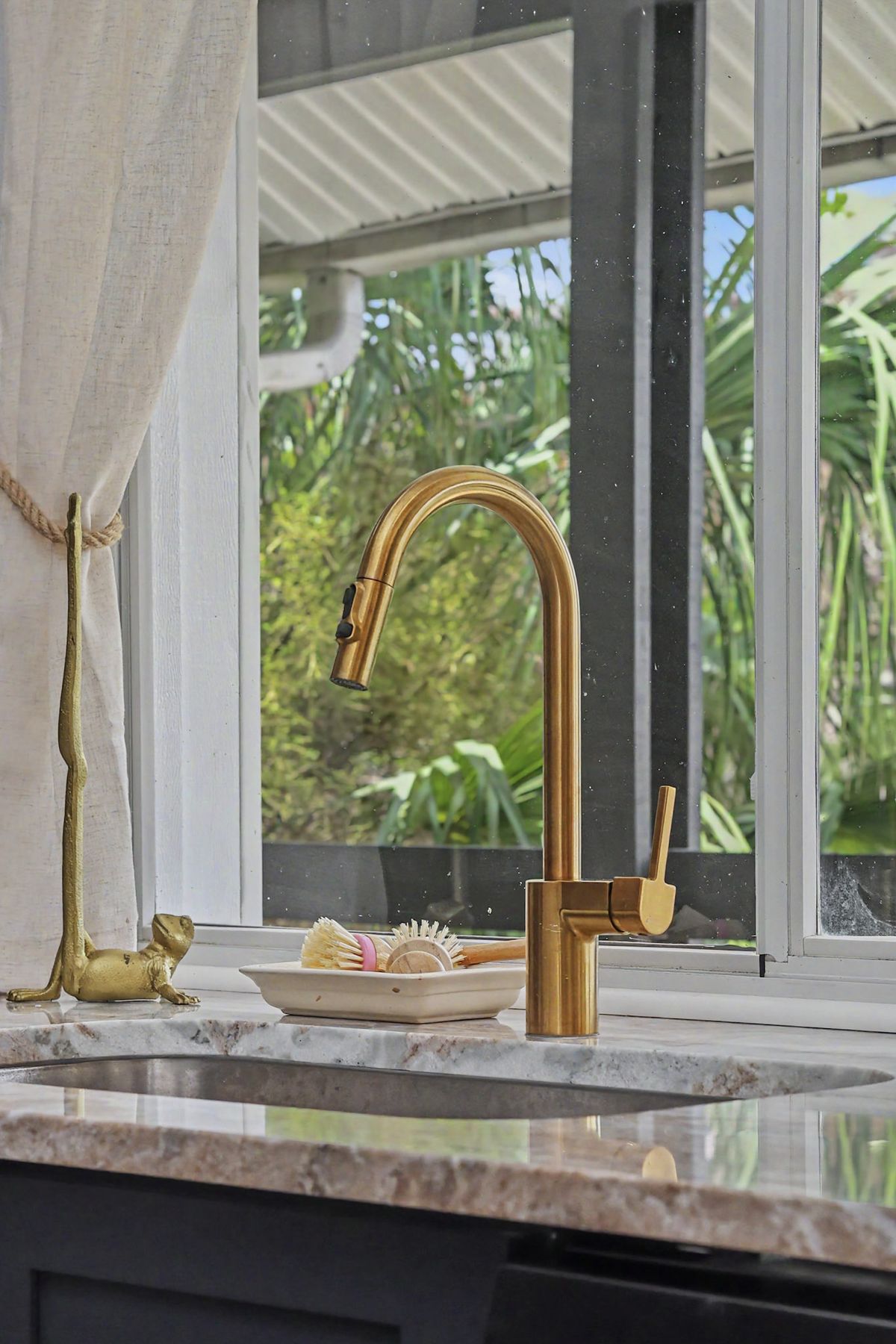 Brass faucet, creek light through the glass at The Rusty Hook Riverhouse, Old Homosassa, Florida
