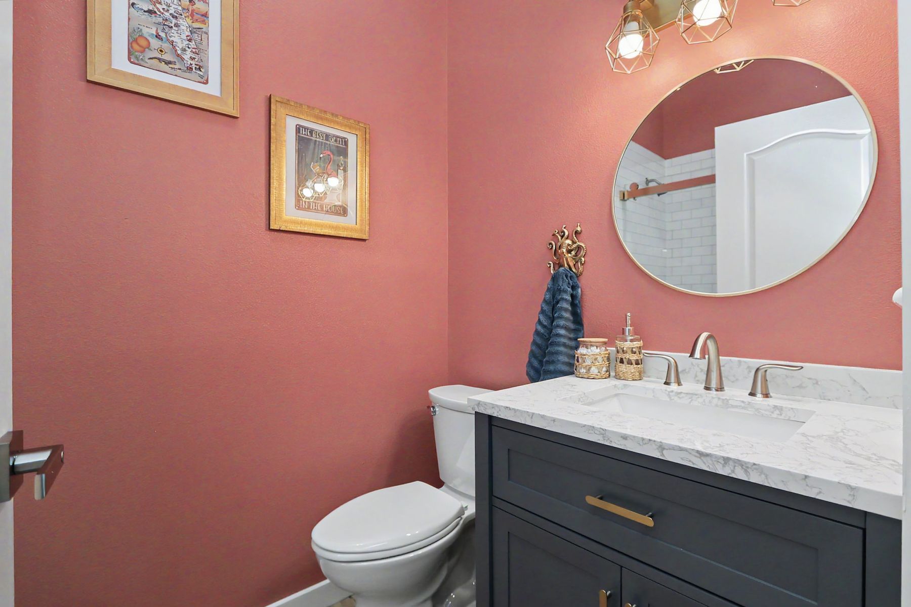 Rose walls, round mirror, navy vanity at The Rusty Hook Riverhouse, Old Homosassa, Florida