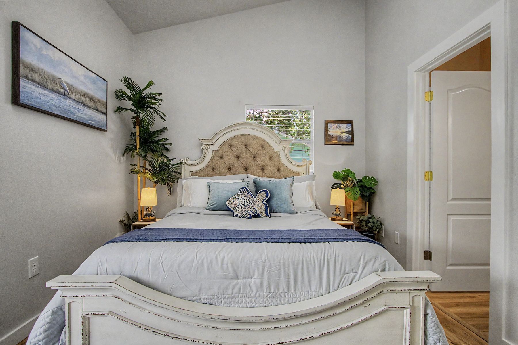 Bed, lamps and the seascape at The Rusty Hook Riverhouse, Old Homosassa, Florida